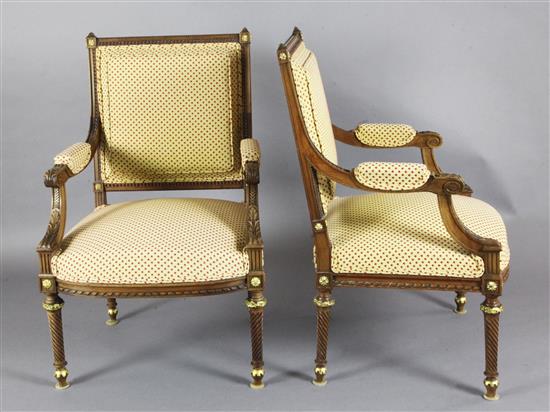 A pair of Louis XVI style parcel gilt carved walnut fauteuil, W.2ft 1in. H.3ft 1in.